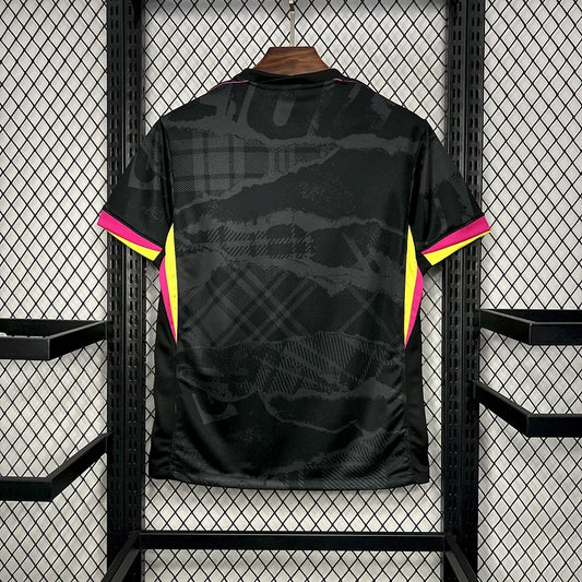 Maillot de football Chelsea 2024-2025 troisième tenue, noir avec détails roses et jaunes, suspendu sur grille métallique