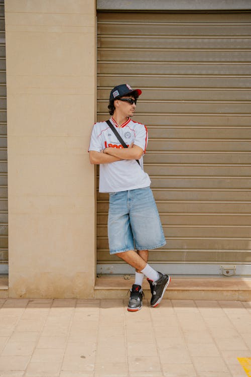 Homme en maillot de foot avec jean et casquette — look streetwear