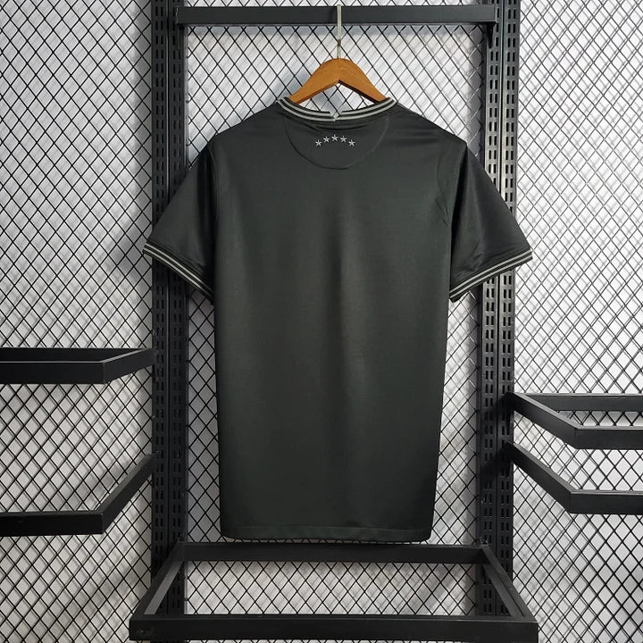 Maillot de football noir avec cinq étoiles blanches à l'arrière, suspendu sur un cintre en bois