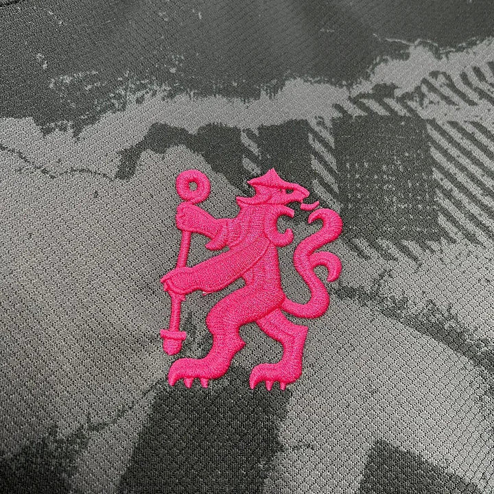 Logo lion rouge brodé sur tissu gris avec motif camouflage maillot foot Chelsea 2024-2025