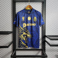 Maillot de football bleu foncé avec motif dragon doré et logos Betano, exposé sur un cintre noir