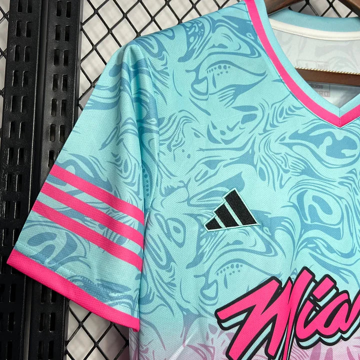 Maillot de football bleu clair avec motifs abstraits, logo Adidas noir et liseré rose vif