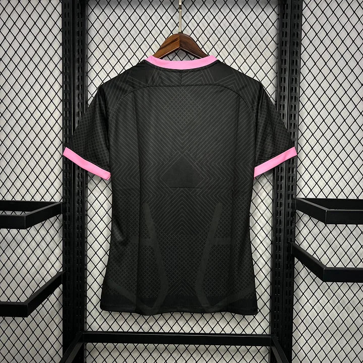 Maillot de football Inter Milan 2024-2025 noir avec bordures roses suspendu sur grille métallique