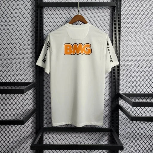 Maillot blanc rétro Neymar 2011-2012 avec logo BMG orange suspendu dans un cadre métallique
